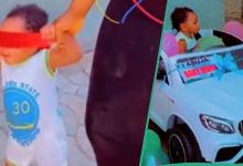 Nigerian baby boy gets a car toy from his parents, drives it with glee
