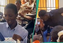 Nigerian students walk up to each other and hand gifts, emotional reaction from...